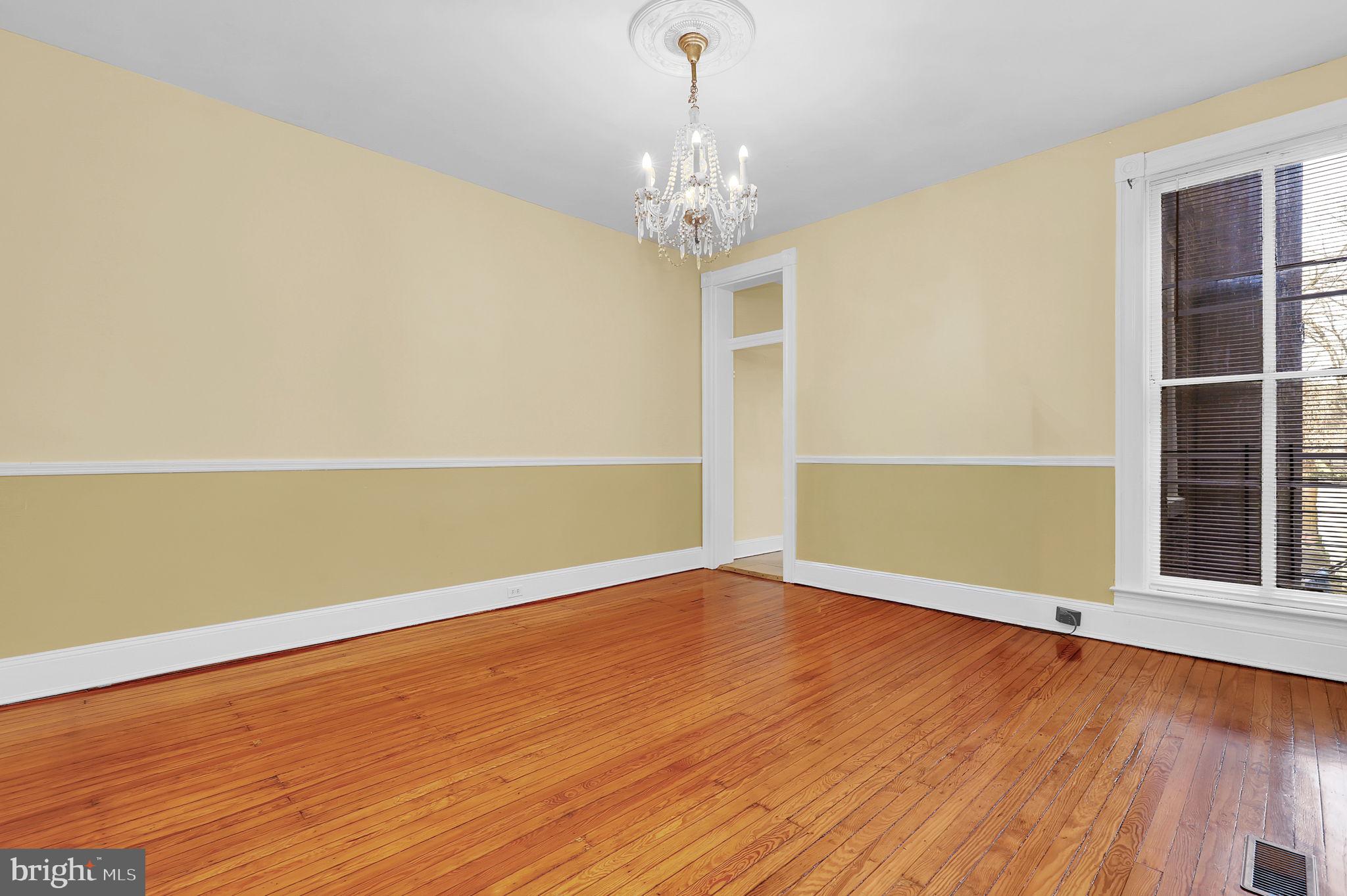 2511 North Calvert Street Baltimore, MD 21218 - Photo 7 of 37 a view of an empty room with wooden floor and a window