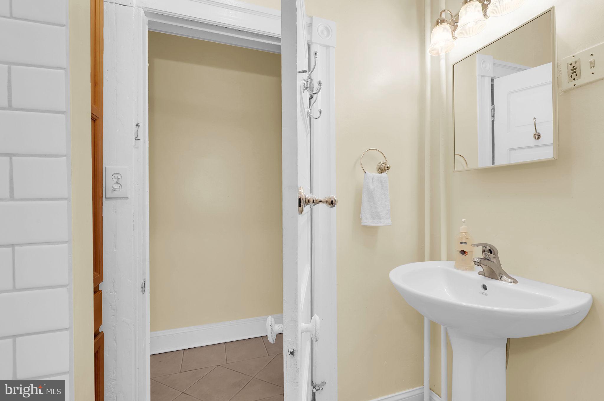 2511 North Calvert Street Baltimore, MD 21218 - Photo 10 of 37 a bathroom with a sink and a mirror