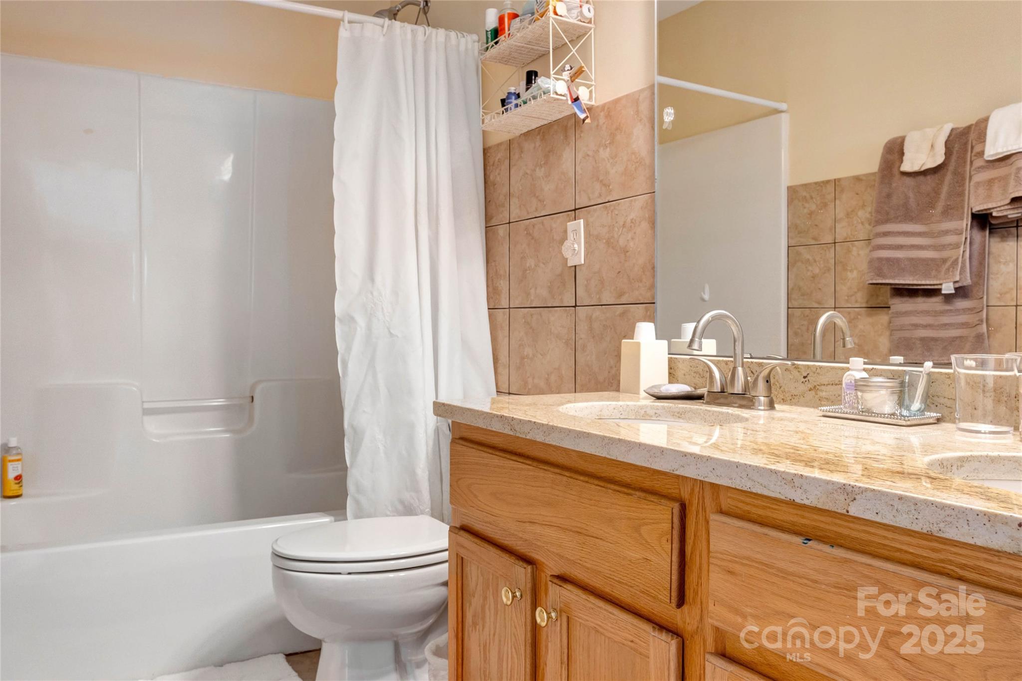 132 Lighthouse Road Mount Holly, NC 28120 - Photo 21 of 43 a bathroom with a granite countertop sink a toilet a mirror and shower