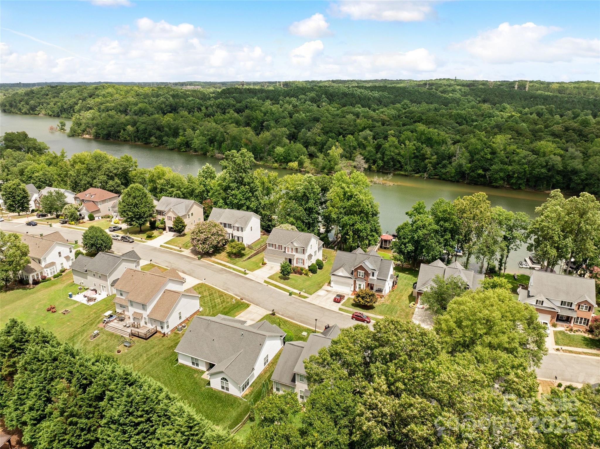 132 Lighthouse Road Mount Holly, NC 28120 - Photo 43 of 43 a view of a lake with a house in the background