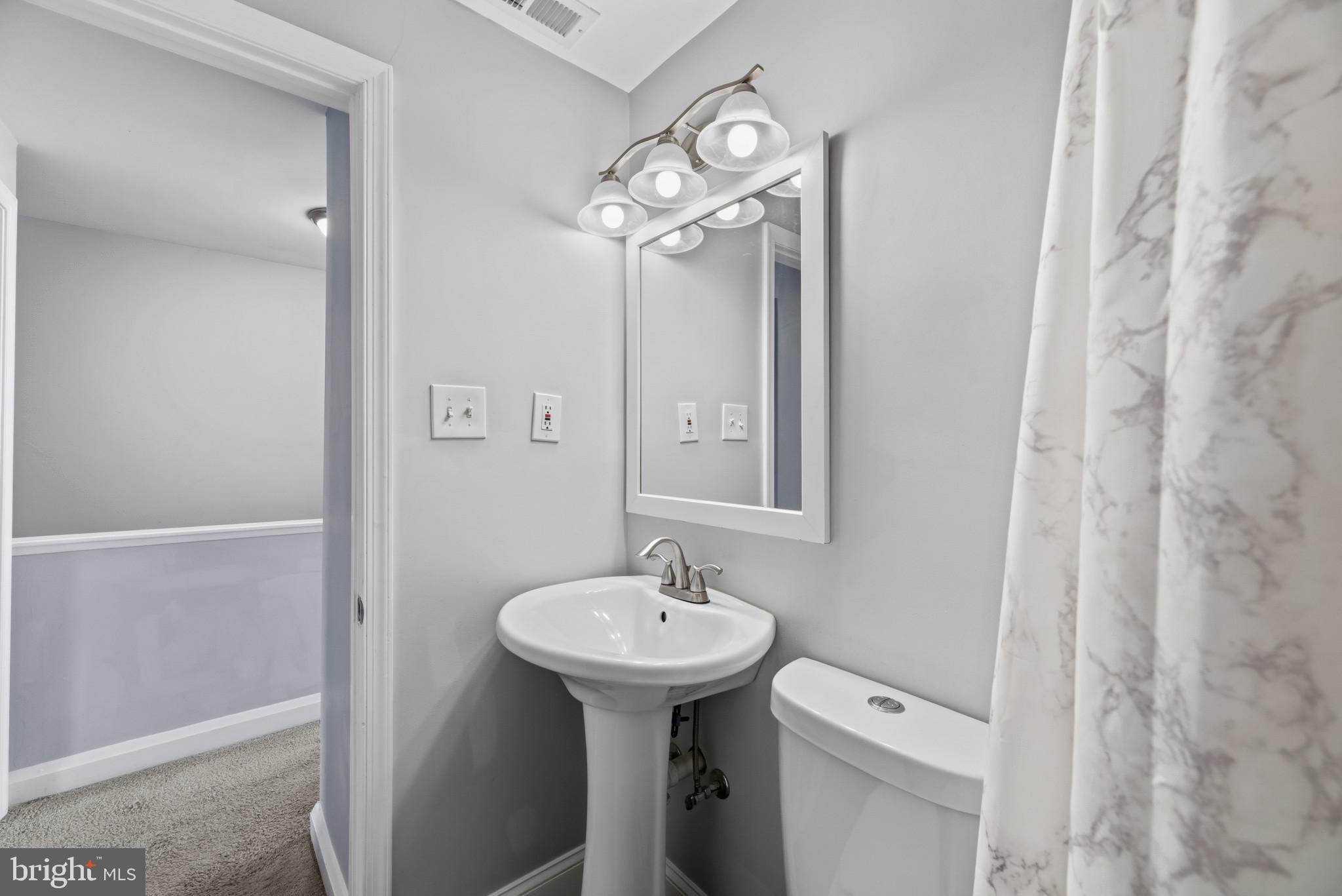 353 Leeanne Road Essex, MD 21221 - Photo 13 of 29 a bathroom with a sink a mirror and a toilet