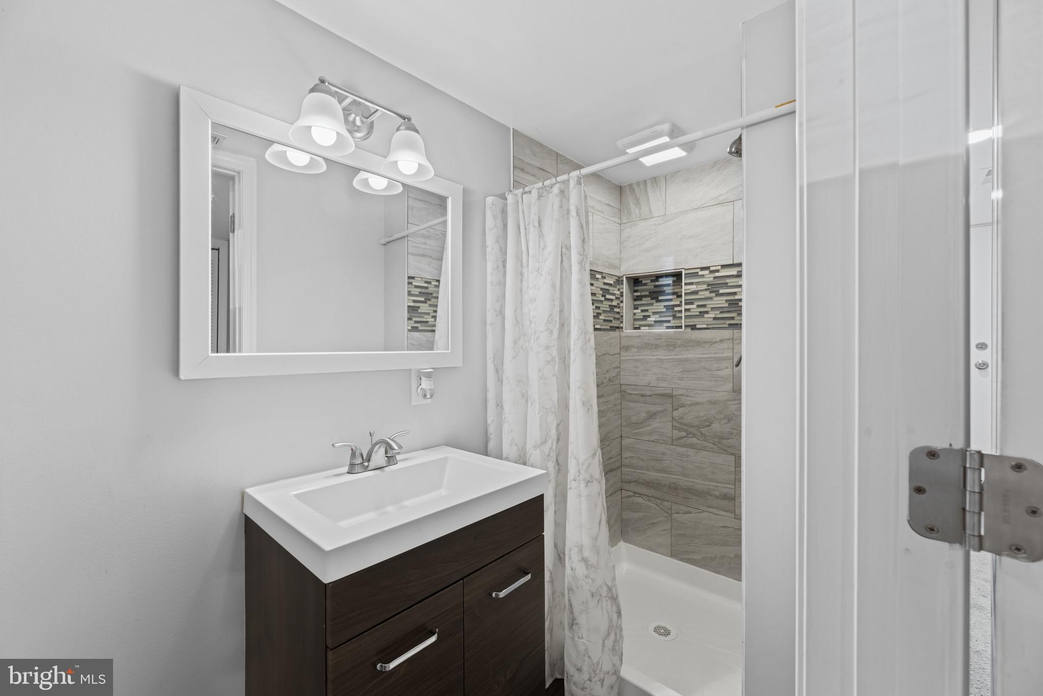 353 Leeanne Road Essex, MD 21221 - Photo 20 of 29 a bathroom with a sink a light fixture and a mirror