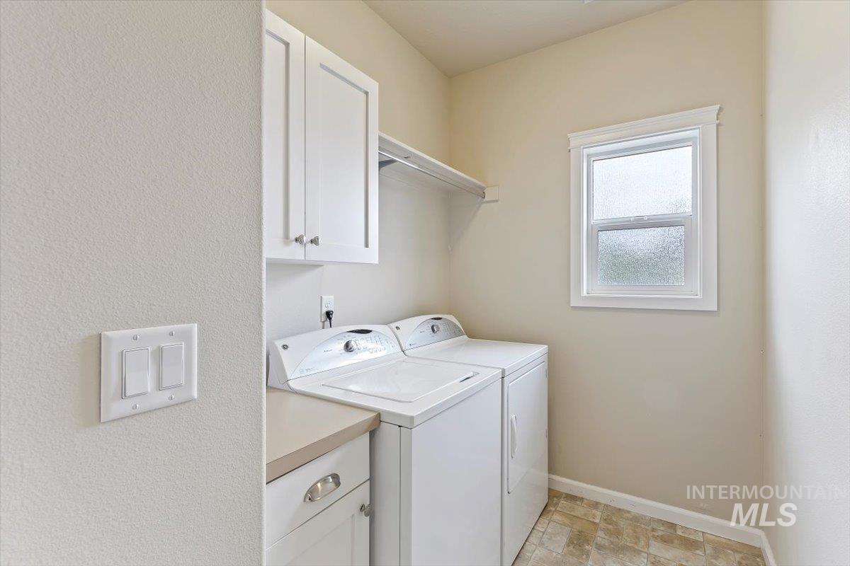 4390 North Five Mile Road Boise, ID 83704 - Photo 21 of 23 Built-in white cabinetry, light-toned countertop, single window, and multi-toned tile flooring