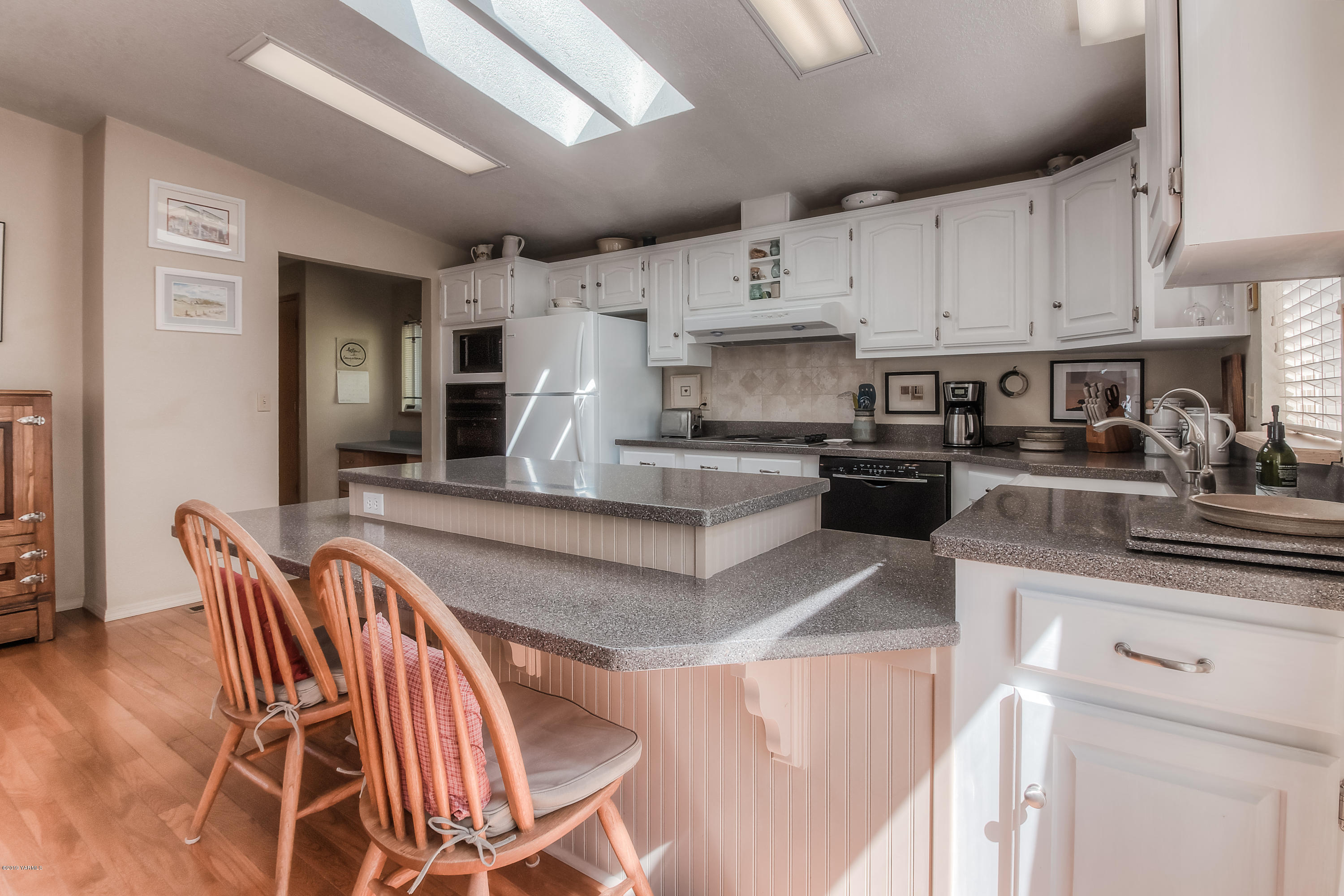 350 Schraeder Road Tieton, WA 98947 - Photo 12 of 39 a kitchen with stainless steel appliances granite countertop a stove top oven a sink a dining table and chairs with white cabinets