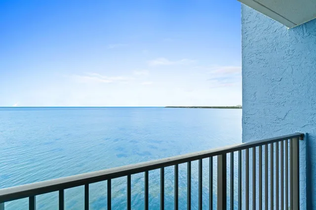 a bathroom with a granite countertop sink a large mirror a toilet and a mirror