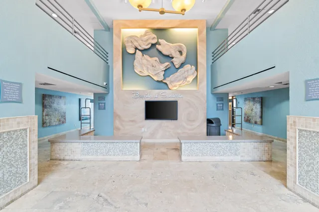 a view of a hallway with a couch and chandelier