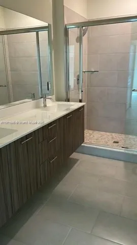 a bathroom with a granite countertop sink a mirror and a bathtub