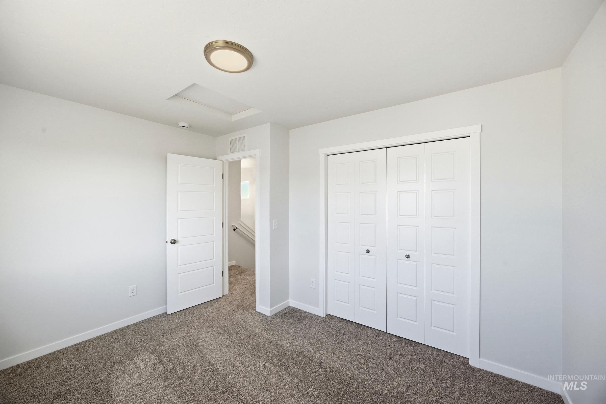 16211 Andes Avenue Caldwell, ID 83607 - Photo 16 of 22 Spacious primary bedroom with neutral carpeting, dual closets with six-panel doors, recessed ceiling lighting, and abundant natural light from multiple windows