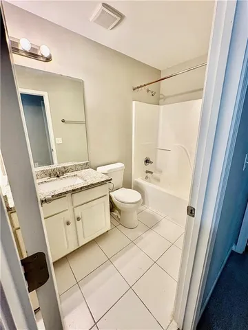 a bathroom with a granite countertop sink a toilet and a shower