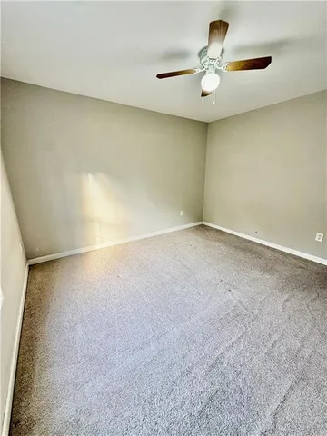 an empty room with a ceiling fan and a window