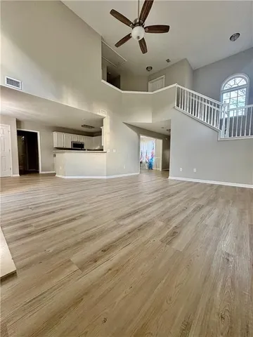 a view of a hallway with wooden floor and staircase