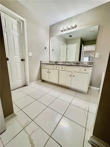 a spacious bathroom with a granite countertop sink mirror and vanity