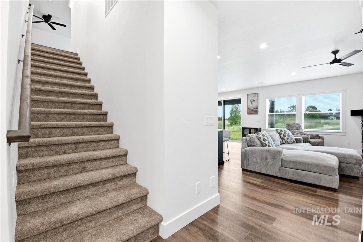 13152 Hawks Bay Road Donnelly, ID 83615 - Photo 12 of 29 Carpeted staircase with dark wood handrail, contrasting with light walls