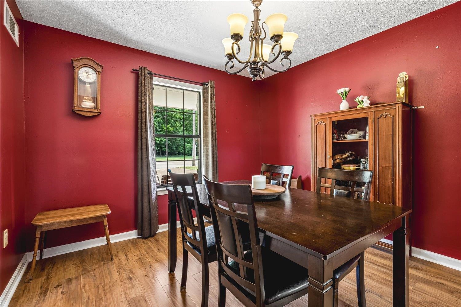 5711 Yale Road Bartlett, TN 38134 - Photo 12 of 29 Dining area featuring wood-finish flooring, a multi-pane window with dark drapes, and a decorative chandelier