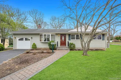 a front view of a house with a garden and yard