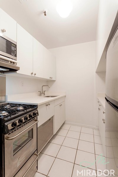 65 4th Avenue, Unit 6C Manhattan, NY 10003 - Photo 5 of 11 a kitchen with a stove a sink and a microwave