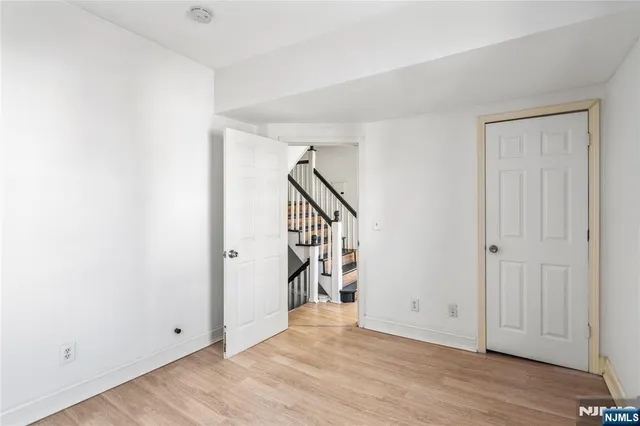 a view of an empty room with wooden floor and entryway