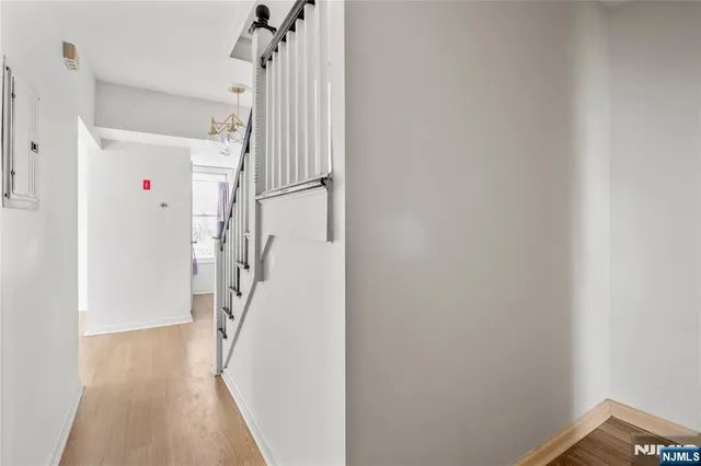 a view of a hallway with a white walls and stairs