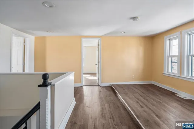 a view of hallway with a window and wooden floor