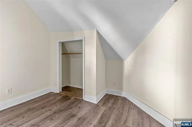 an empty room with wooden floor and closet