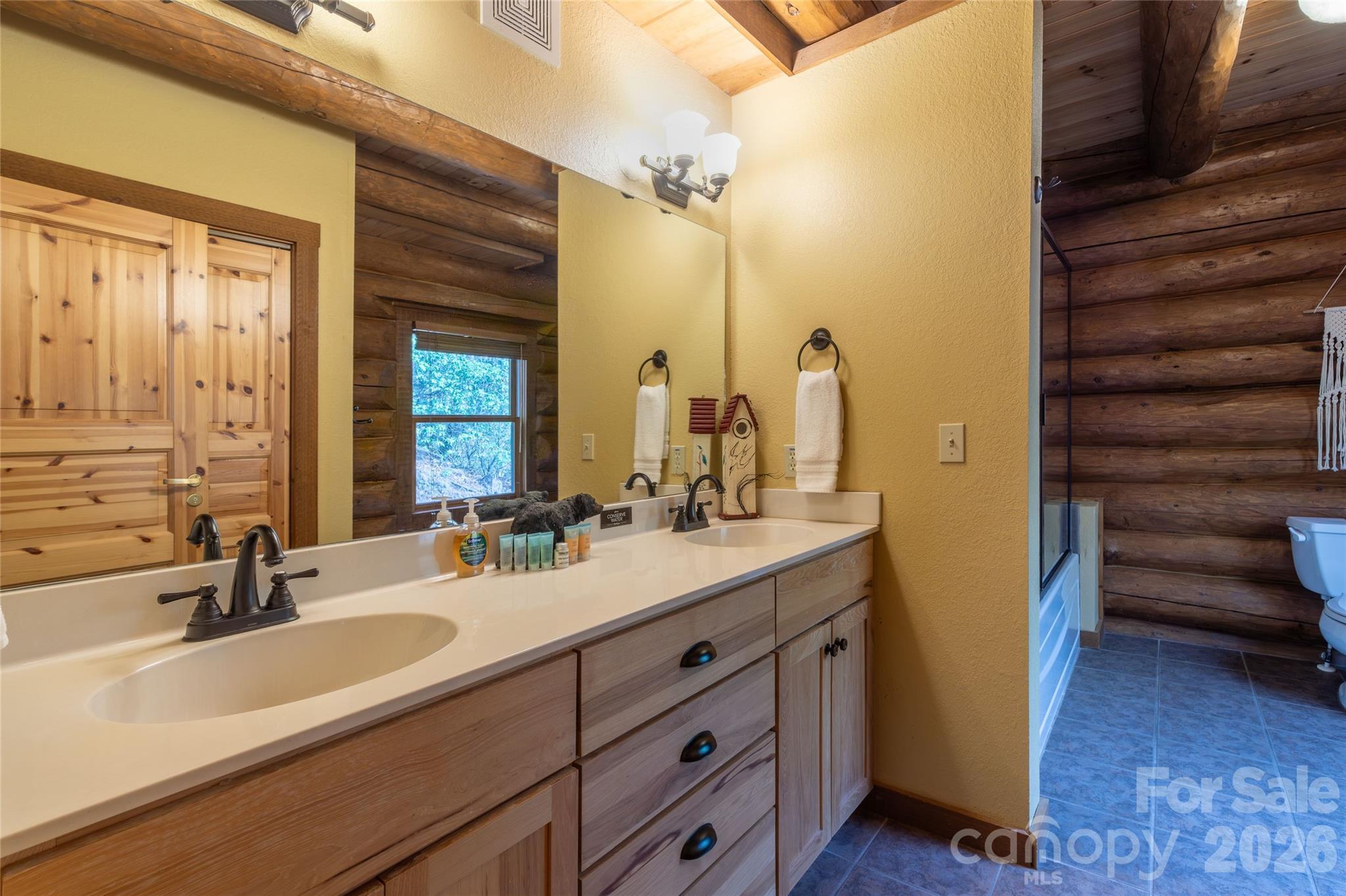 1391 Still Branch Road Sylva, NC 28779 - Photo 20 of 40 a bathroom with a double vanity sink a mirror and a shower