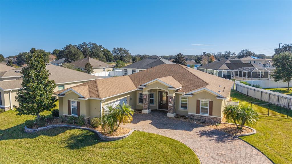an aerial view of a house with swimming pool and furniture