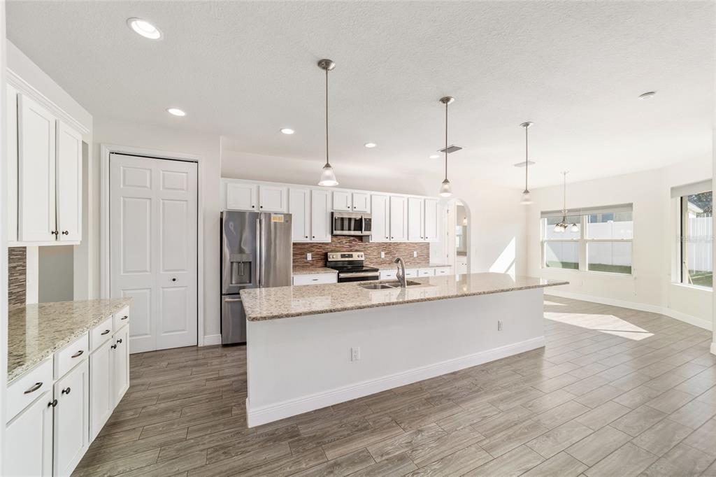 6429 Southwest 45th Avenue Ocala, FL 34474 - Photo 13 of 56 a large kitchen with granite countertop a large counter top a sink stainless steel appliances and cabinets
