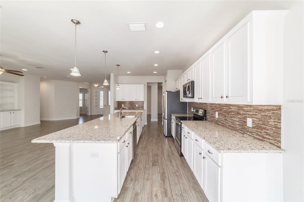 6429 Southwest 45th Avenue Ocala, FL 34474 - Photo 16 of 56 a large kitchen with granite countertop a large counter top and stainless steel appliances
