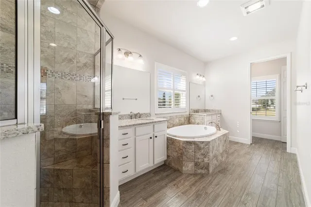 a view of a big room with wooden floor and a kitchen