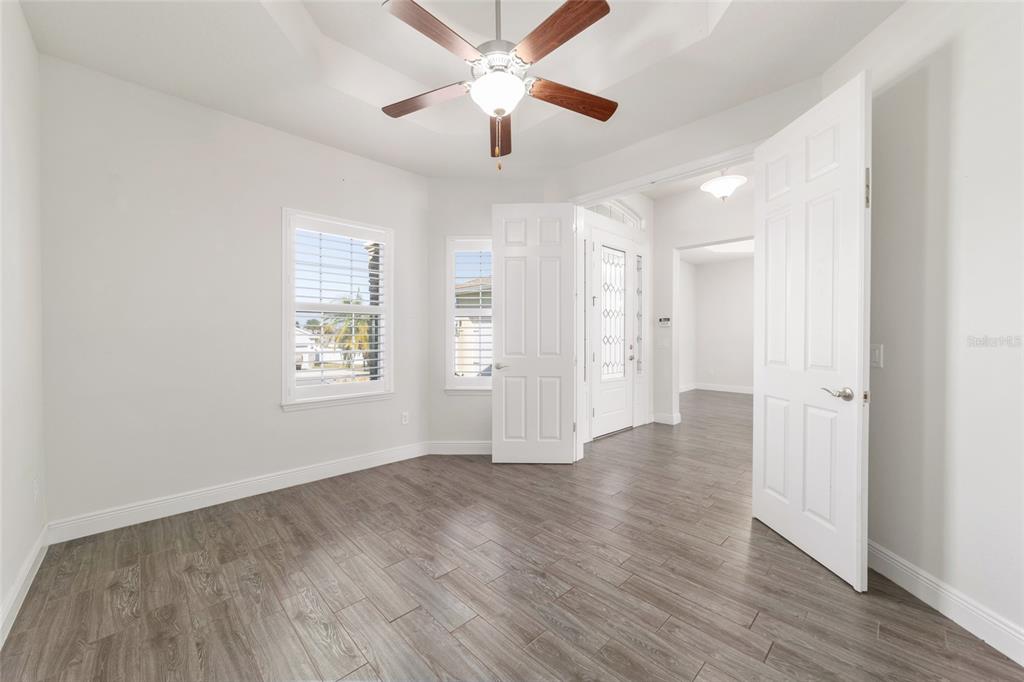 6429 Southwest 45th Avenue Ocala, FL 34474 - Photo 33 of 56 an empty room with wooden floor ceiling fan and windows