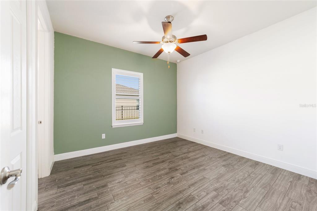 6429 Southwest 45th Avenue Ocala, FL 34474 - Photo 35 of 56 an empty room with wooden floor fan and windows