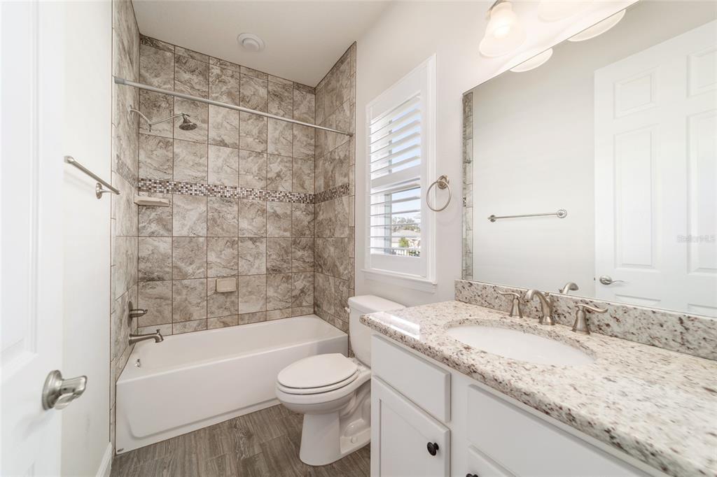 6429 Southwest 45th Avenue Ocala, FL 34474 - Photo 38 of 56 a bathroom with a granite countertop sink a toilet and bathtub