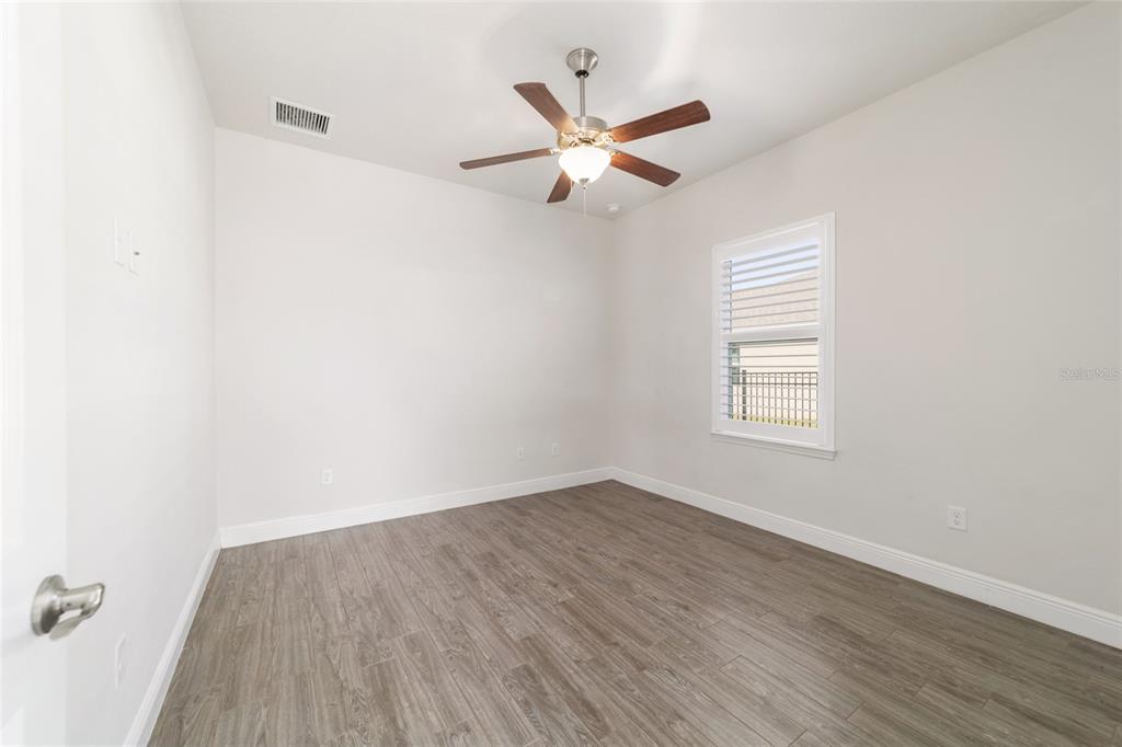 6429 Southwest 45th Avenue Ocala, FL 34474 - Photo 39 of 56 an empty room with wooden floor fan and windows