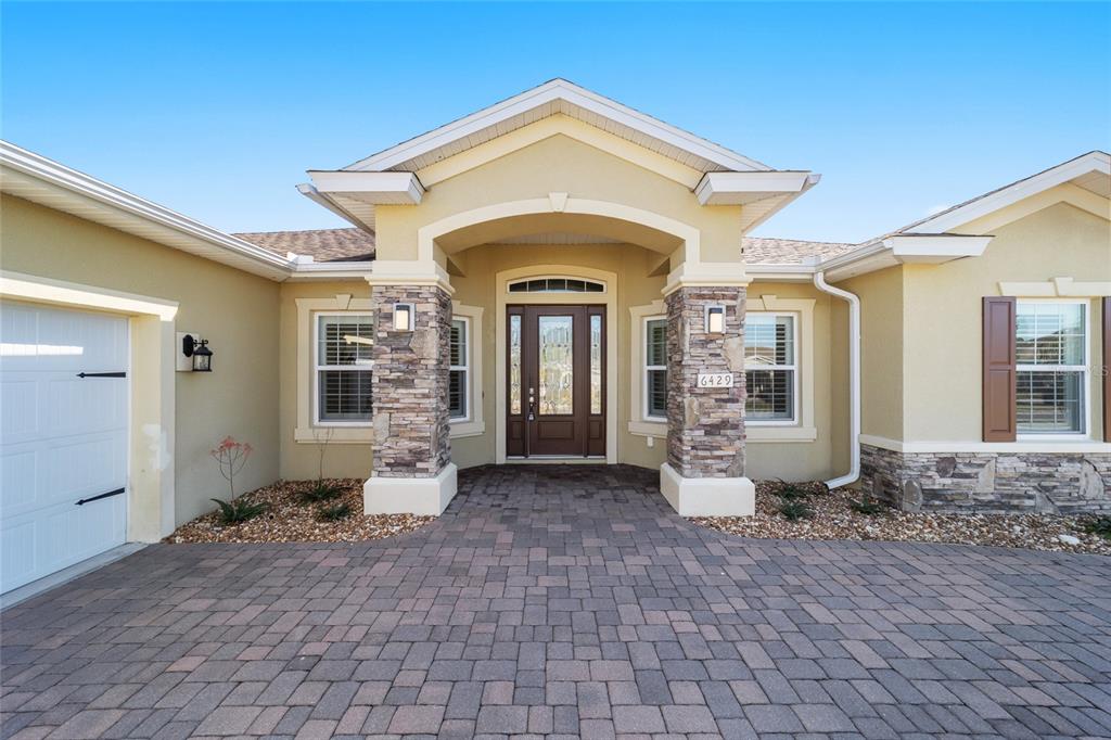 6429 Southwest 45th Avenue Ocala, FL 34474 - Photo 4 of 56 a view of a big house with entryway and wooden fence