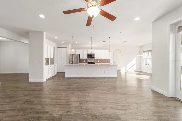 a view of kitchen with refrigerator stove and wooden floor