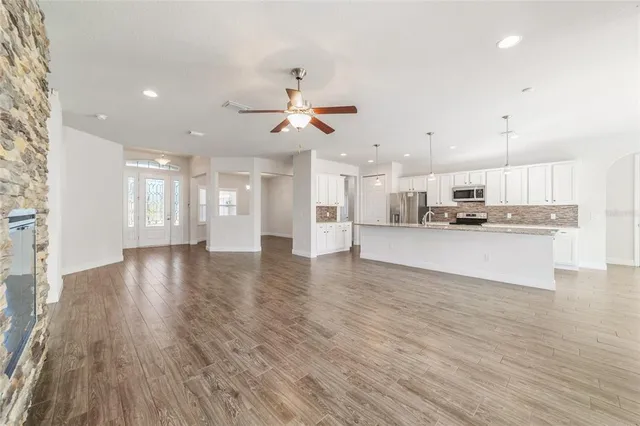 a view of empty room with wooden floor and fireplace