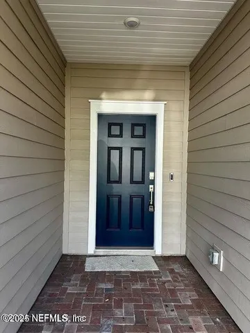 a view of a hallway with wooden floor and a living room