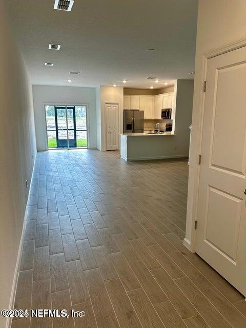 389 Belfort Court St. Augustine, FL 32092 - Photo 4 of 24 a view of a hallway with wooden floor and a living room