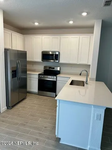 a kitchen with cabinets and stainless steel appliances