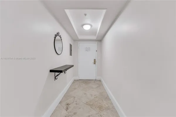 a living room with furniture a flat screen tv and a refrigerator