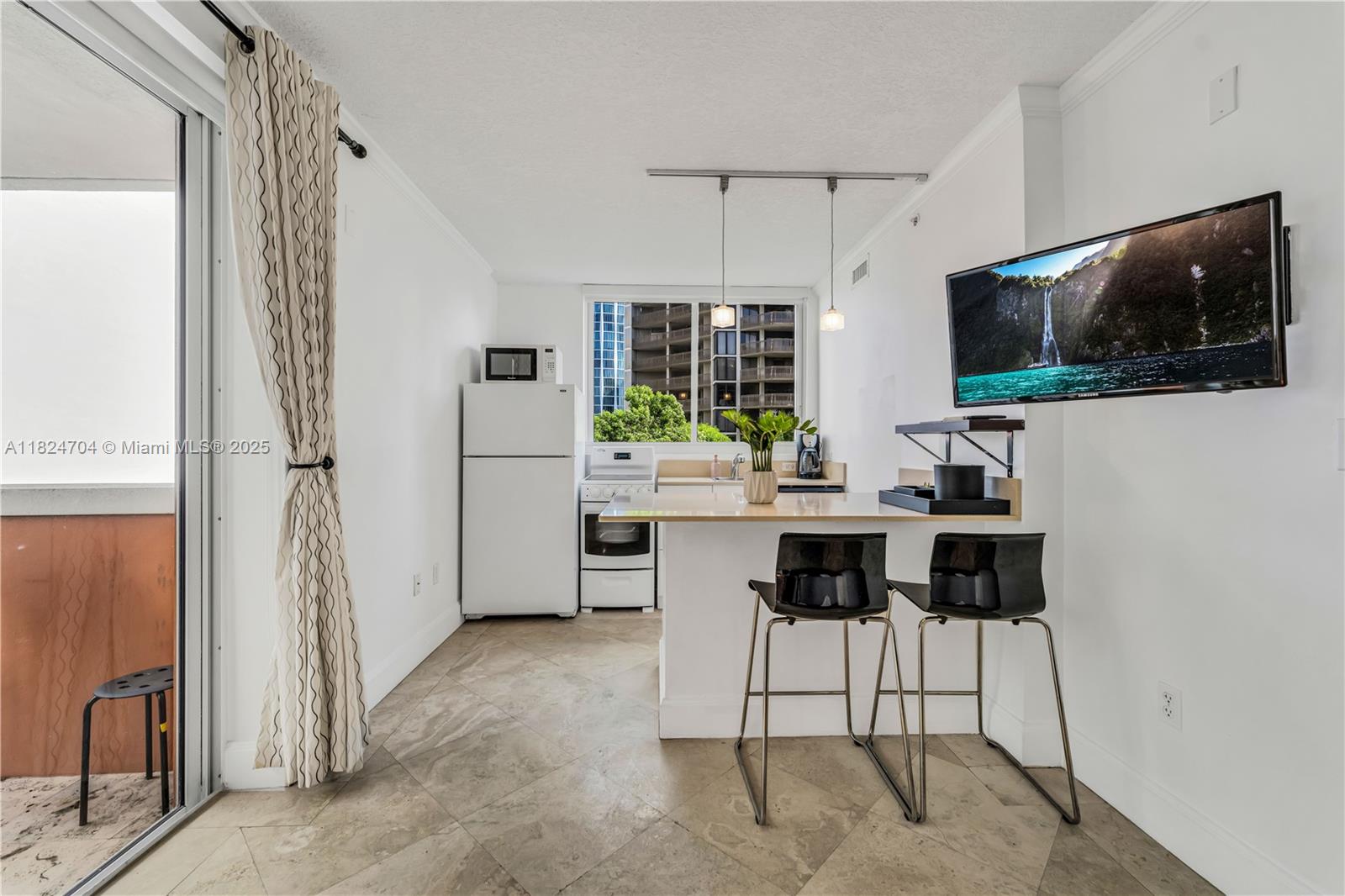 2951 South Bayshore Drive, Unit 717 Miami, FL 33133 - Photo 13 of 31 a living room with furniture a flat screen tv and a refrigerator