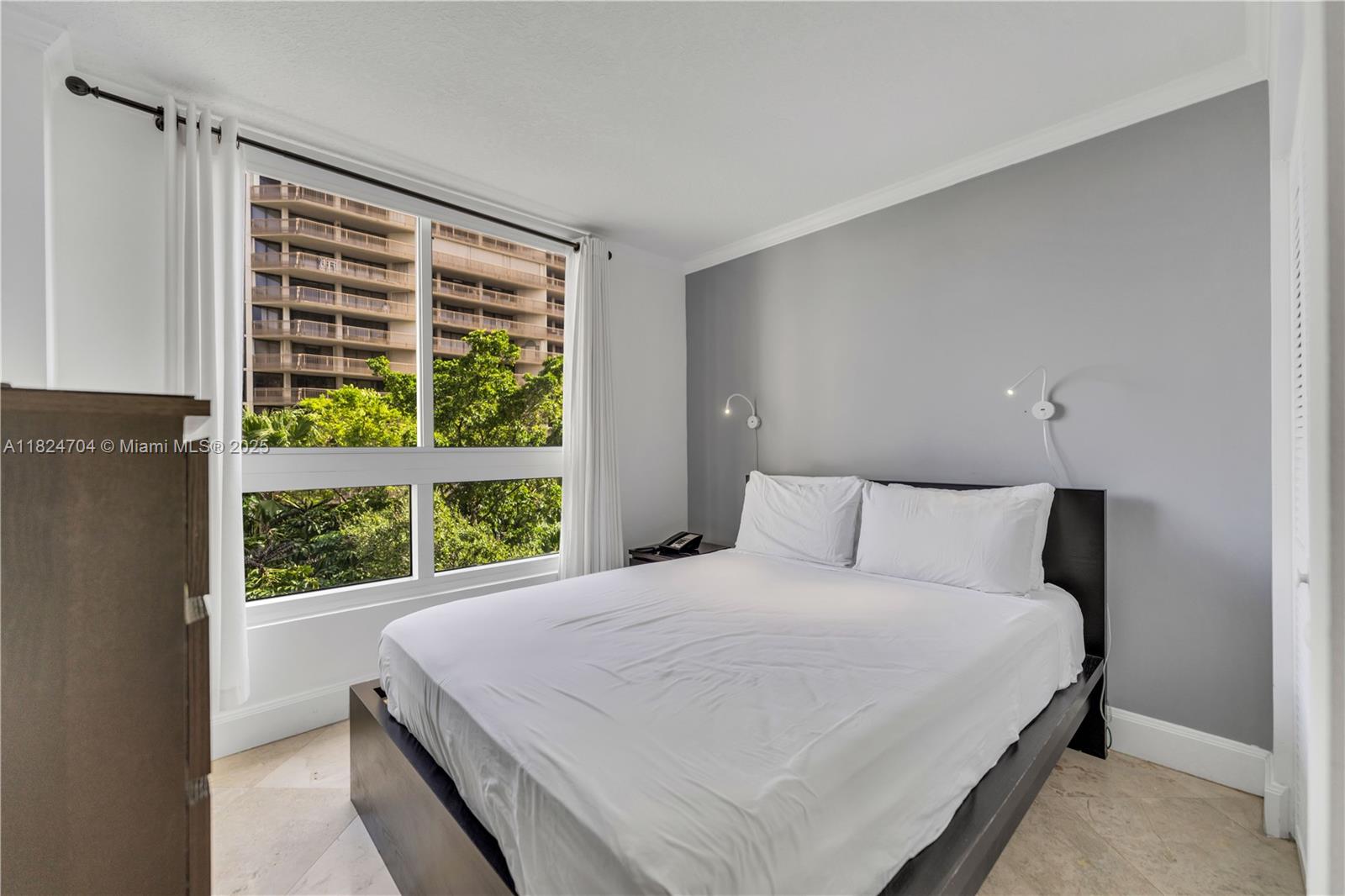 2951 South Bayshore Drive, Unit 717 Miami, FL 33133 - Photo 16 of 31 a large bed sitting in a bedroom next to a window