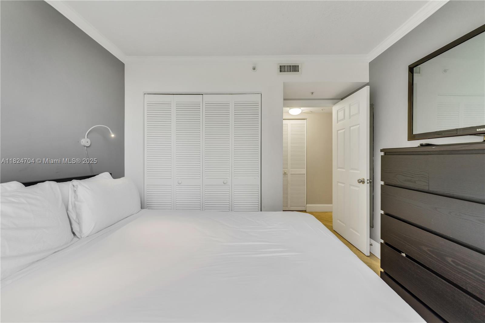 2951 South Bayshore Drive, Unit 717 Miami, FL 33133 - Photo 17 of 31 a large white bedroom with a large bed and furniture