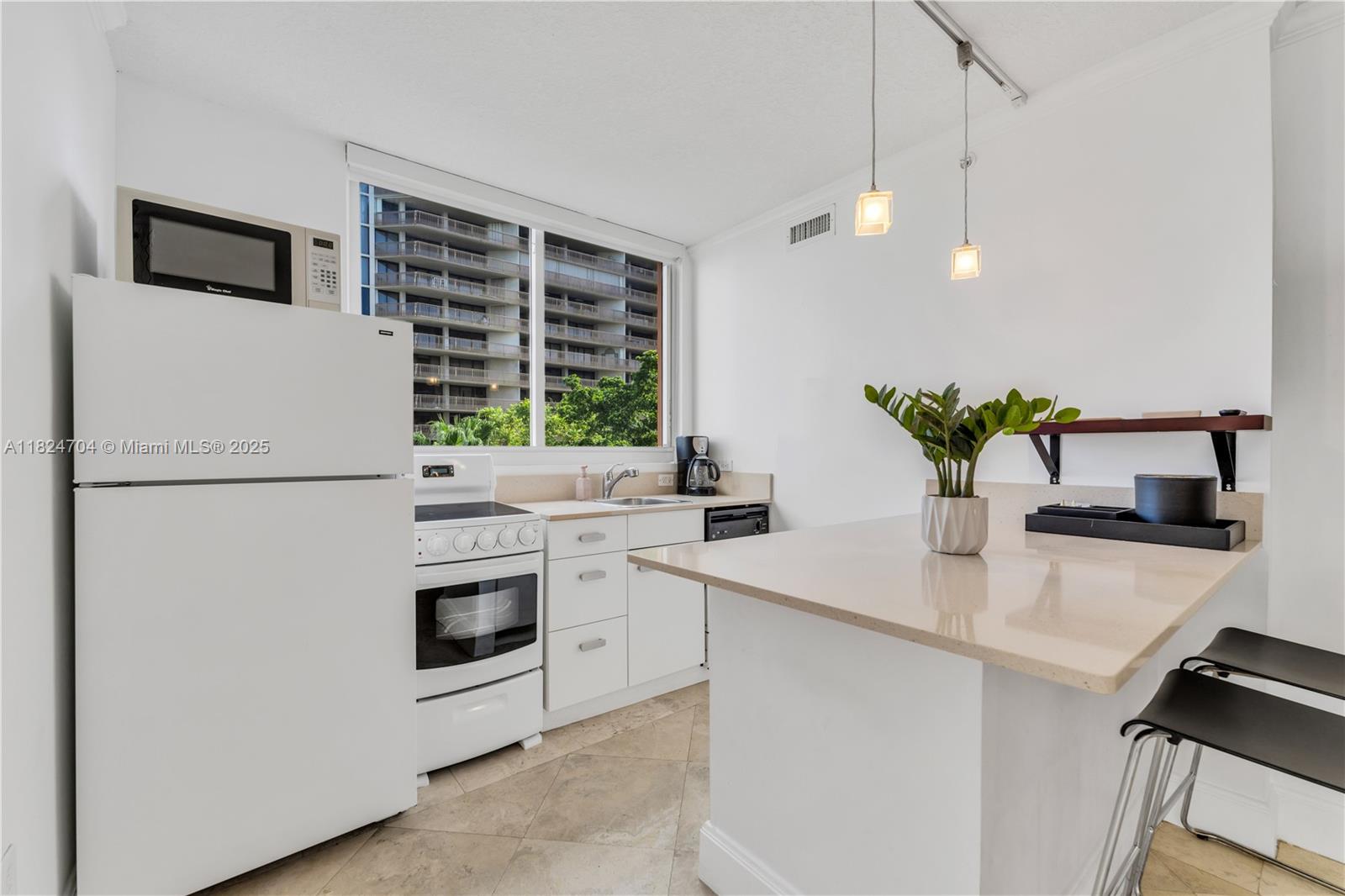2951 South Bayshore Drive, Unit 717 Miami, FL 33133 - Photo 20 of 31 a kitchen with a sink a refrigerator and a stove