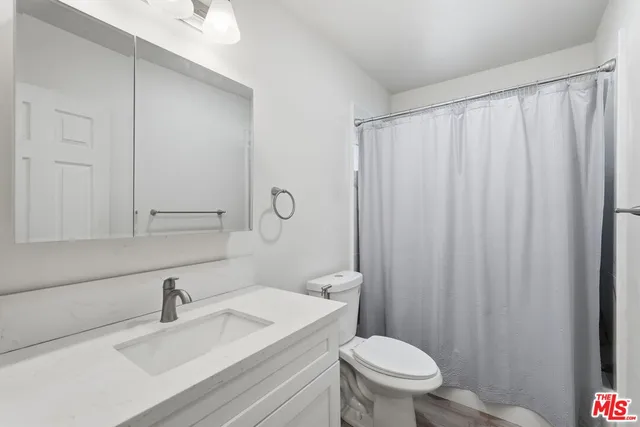 a bedroom with a bed and two window