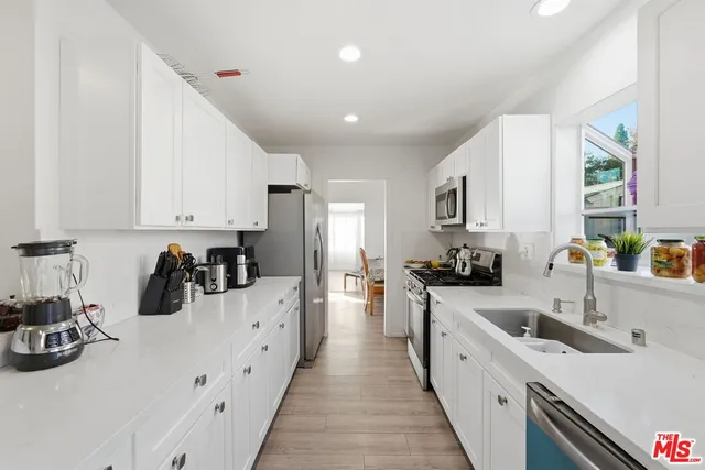 a kitchen with sink a stove and cabinets