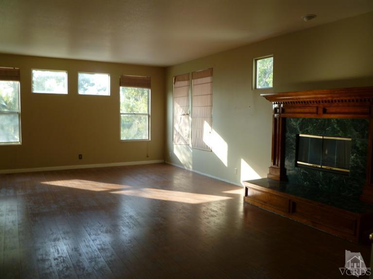 11667 Pinedale Road Moorpark, CA 93021 - Photo 2 of 7 a view of an empty room with wooden floor and a fireplace