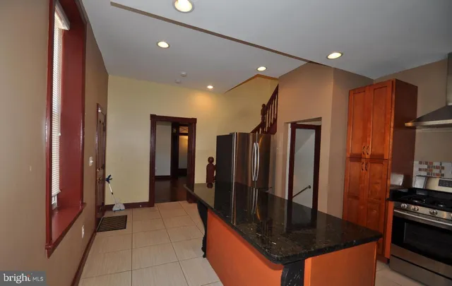 a kitchen with stainless steel appliances granite countertop a refrigerator a stove and a sink