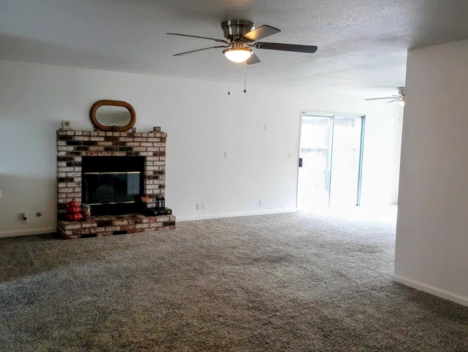 1432 Don Pedro Road Ceres, CA 95307 - Photo 5 of 56 a view of an empty room with a fireplace and fan
