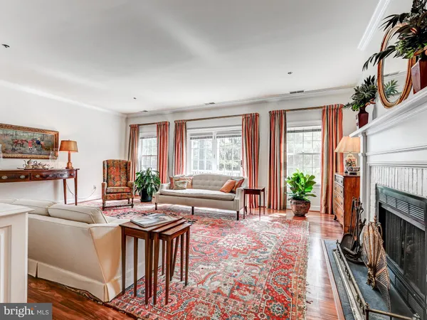 a living room with furniture a fireplace and a large window
